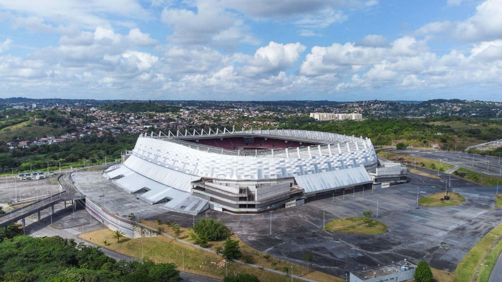 Em foto de visão aérea, Arena de Pernambuco é registrada sob o céu azul de Recife