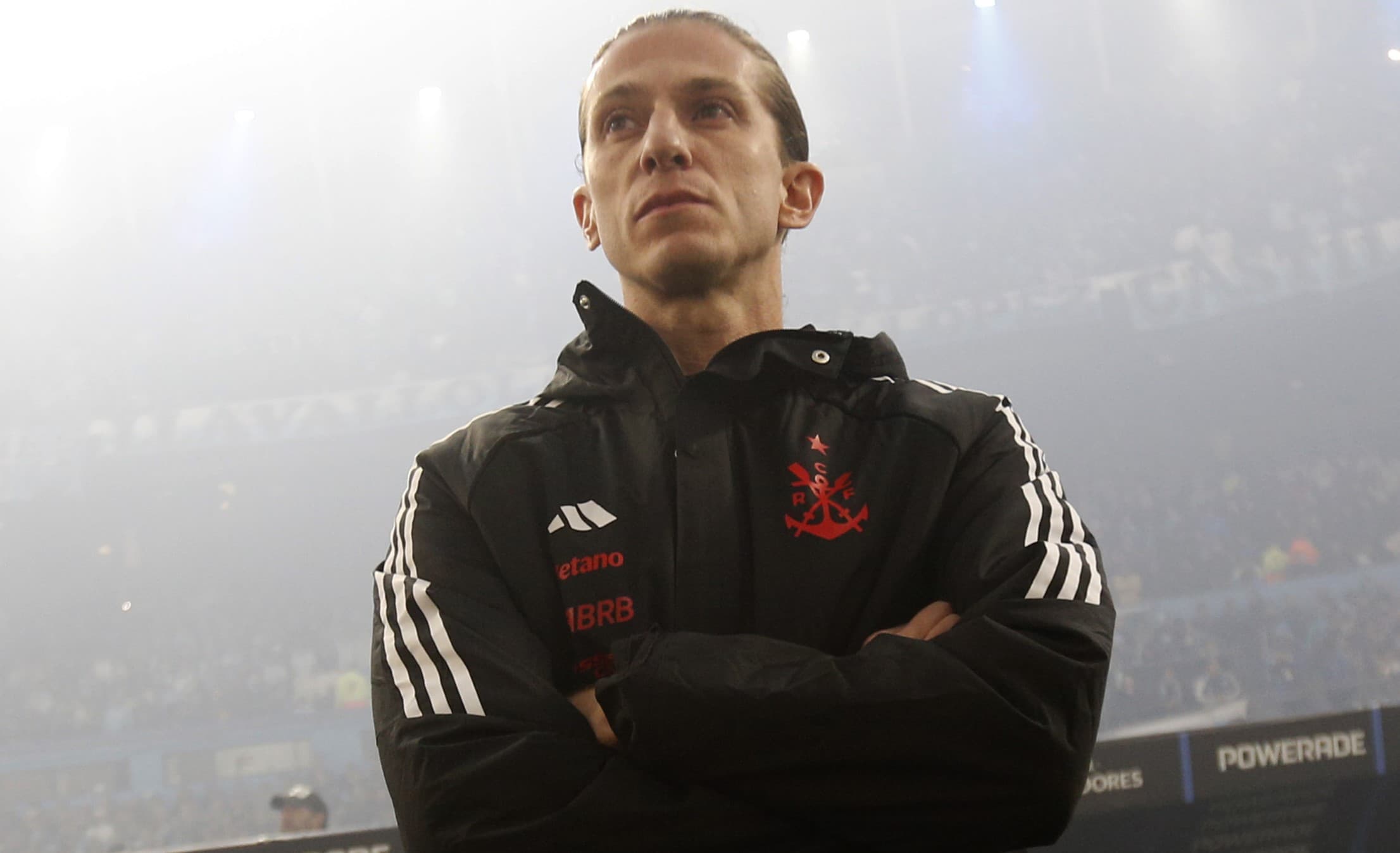 Filipe Luís de braços cruzados enquanto aguarda o apito inicial de Racing x Flamengo no El Cilindro