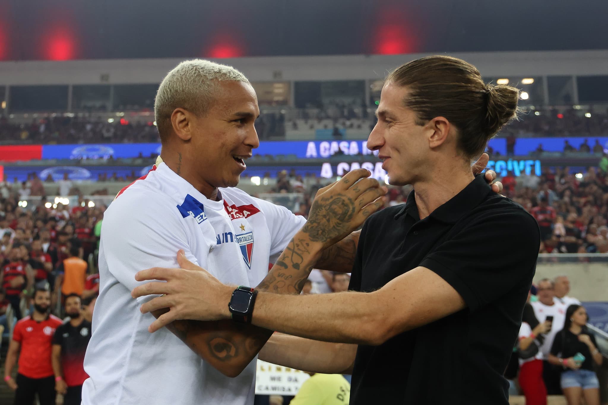 Deyverson, do Fortaleza, conversa com Filipe Luís, técnico do Flamengo, antes do jogo pelo Brasileirão 2025 no Maracanã, em clima amistoso e estádio cheio ao fundo.
