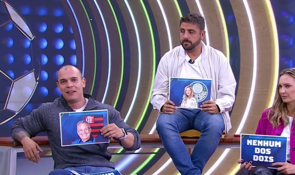 Mano segura card com foto de Bap e escudo do Flamengo, Nicola com card com fotos de Leila Pereira e escudo do Palmeiras em brincadeira durante Arena SBT