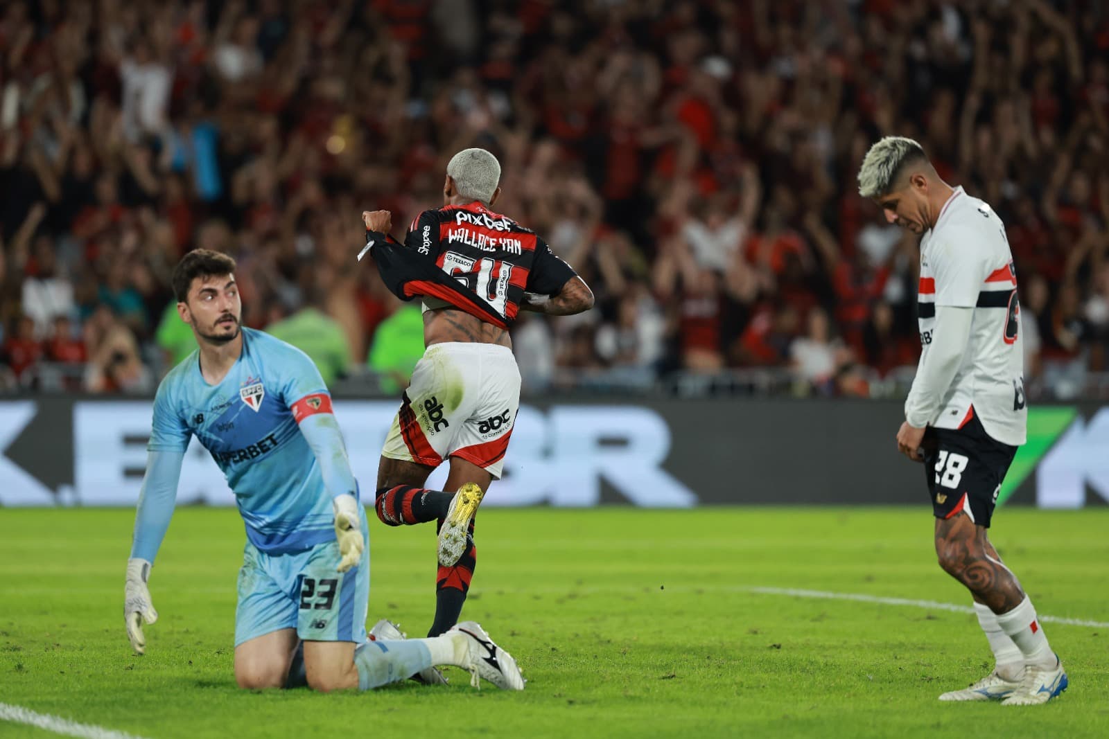 Wallace Yan comemora tirando a camisa, enquanto jogadores do São Paulo se olham com lamentação no Maracanã