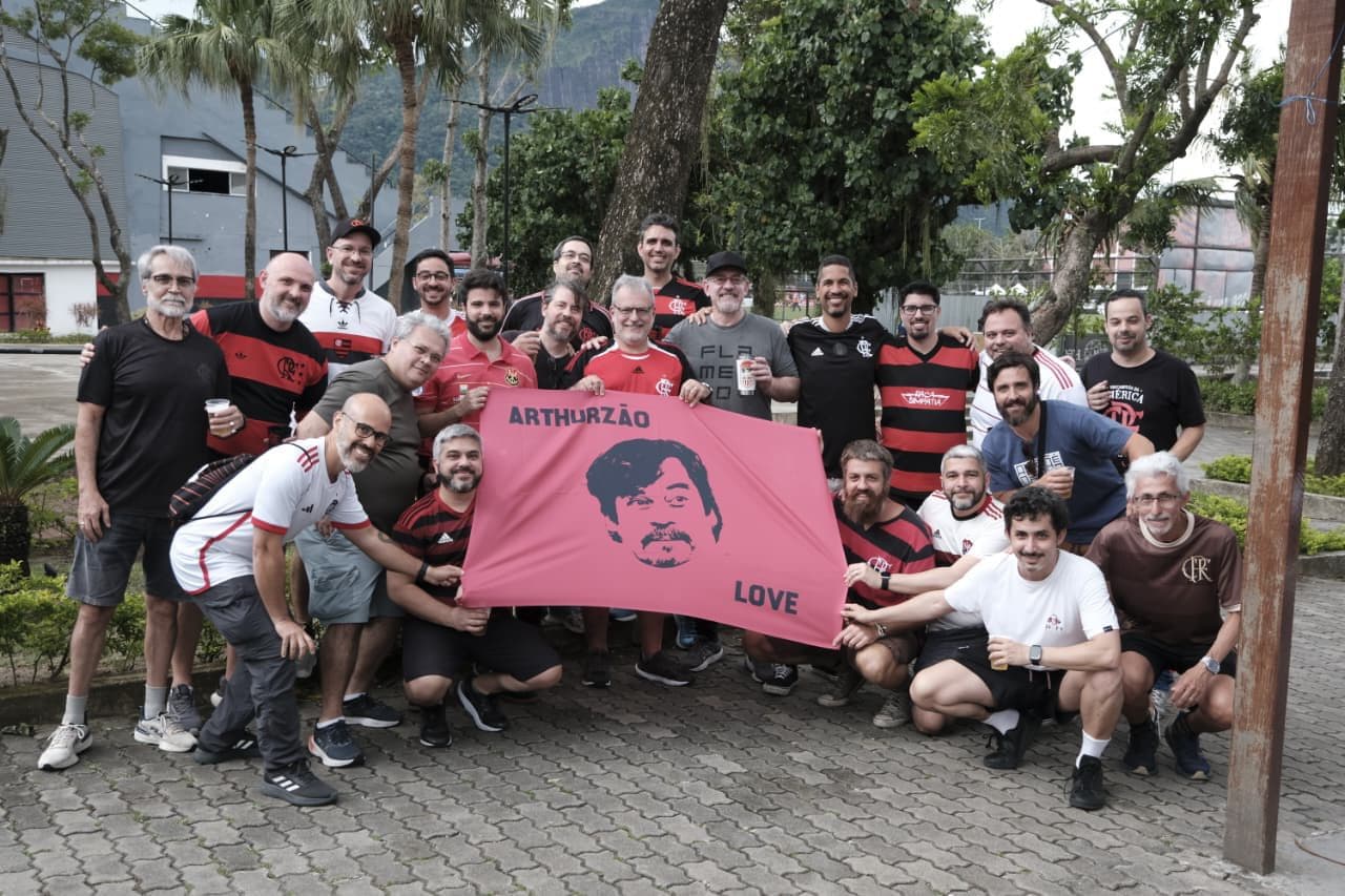 Amigos e torcedores rubro-negros se reúnem em homenagem a Arthur Muhlenberg, a Voz da Torcida do Flamengo, com o bandeirão “Arthurzão Love” aberto em confraternização no clube.