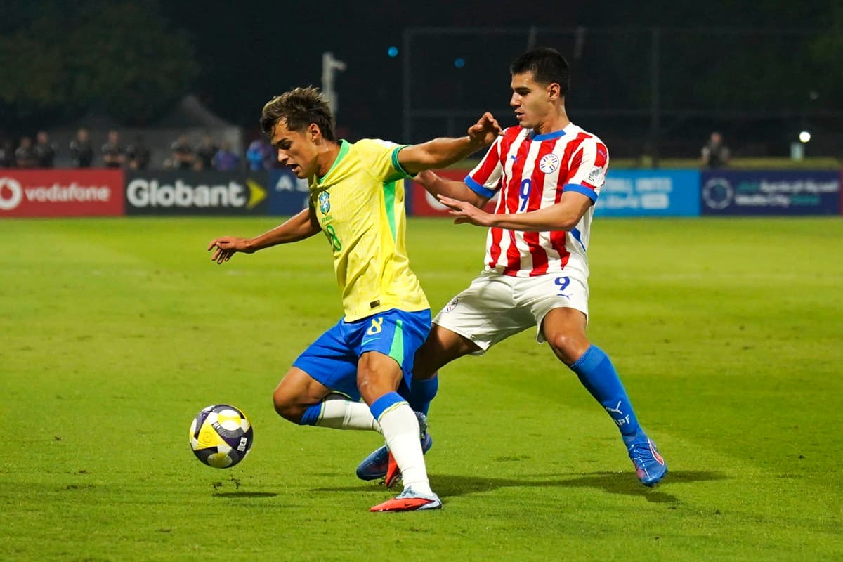 Tiaguinho protege a bola em disputa com jogador do Paraguai na Copa do Mundo
