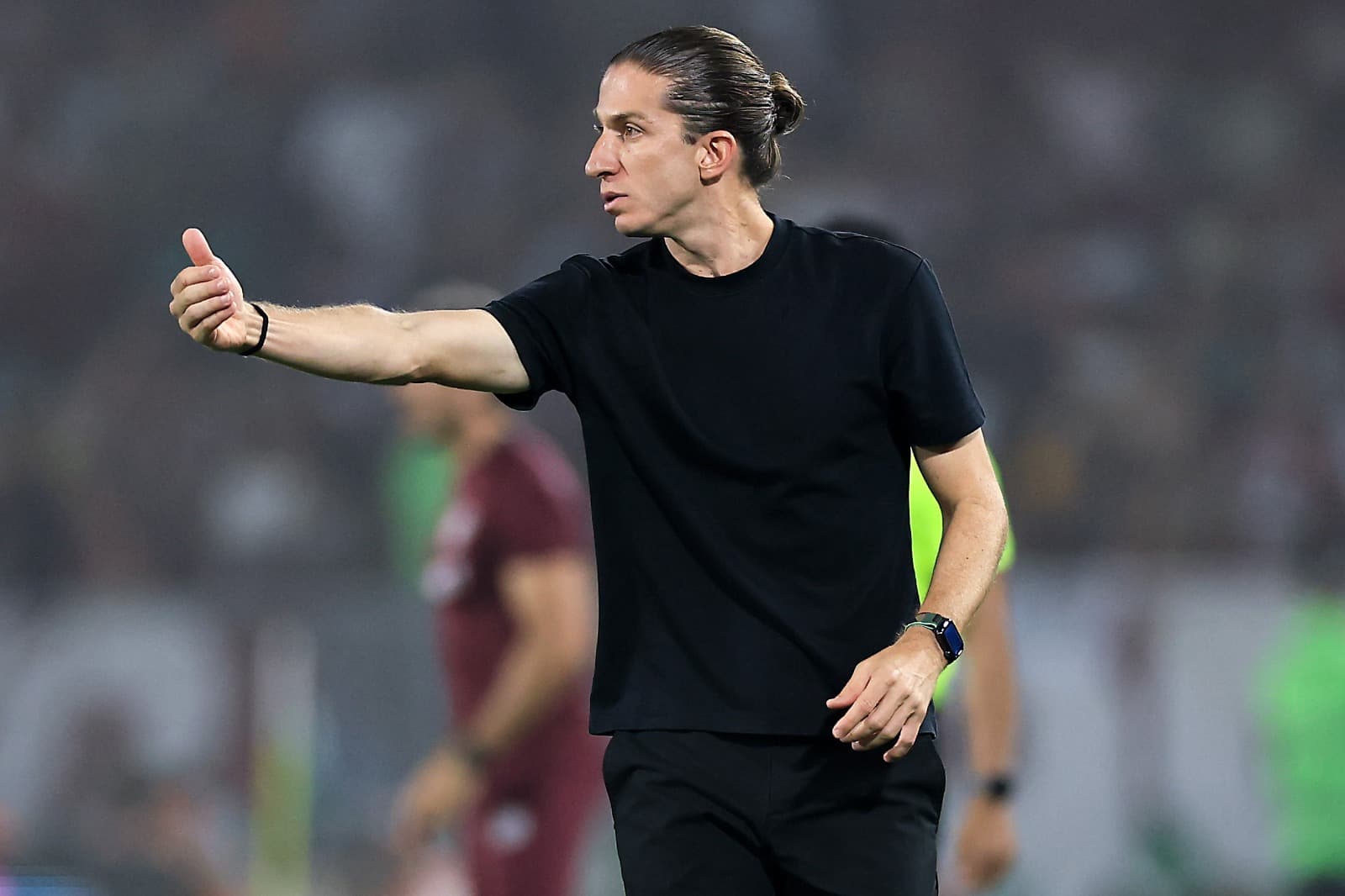 Filipe Luís aponta com a mão direita para passar instrução durante o FlaxFlu