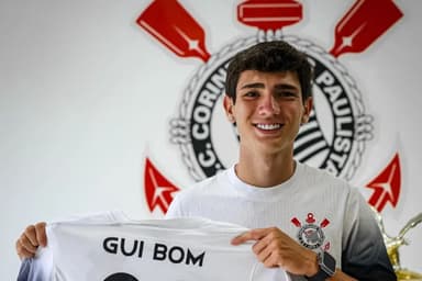 Gui Bom, atacante do sub-17 do Corinthians, posa para foto sorrindo e segurando uma camisa com seu nome