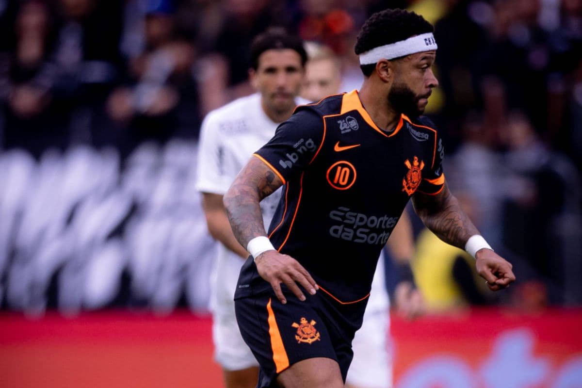 Memphis Depay, jogador do Corinthians, em ação contra o Ceará pelo Campeonato Brasileiro 2025. O atacante holandês usa o uniforme três do Corinthians, preto com detalhs em laranja, e usa uma faixa branca na cabeça.