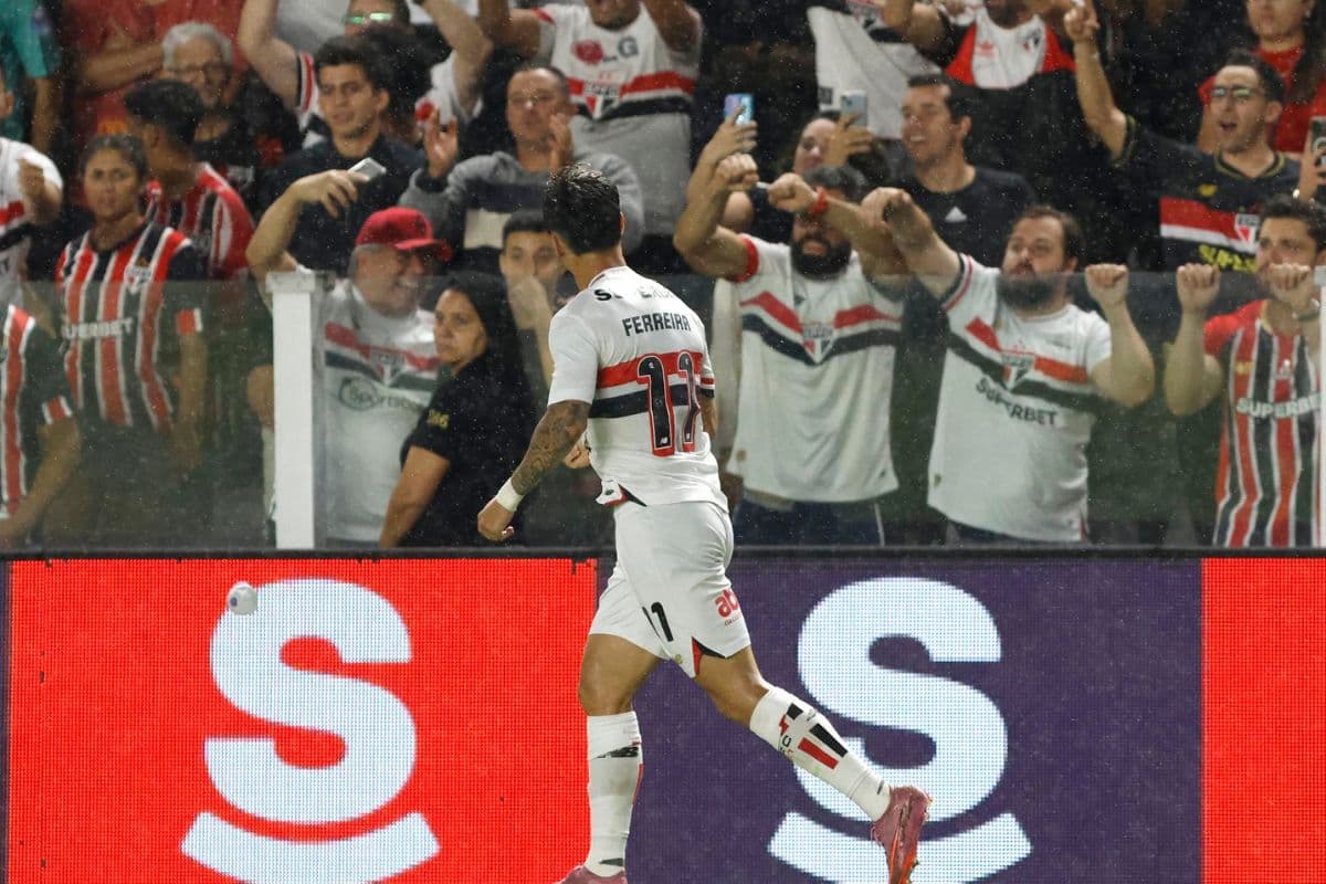 Ferreirinha, atacante do São Paulo, comemora gol marcado contra o Flamengo em frente a torcedores do clube que celebram o feito nas arquibancadas do estádio Vila Belmiro