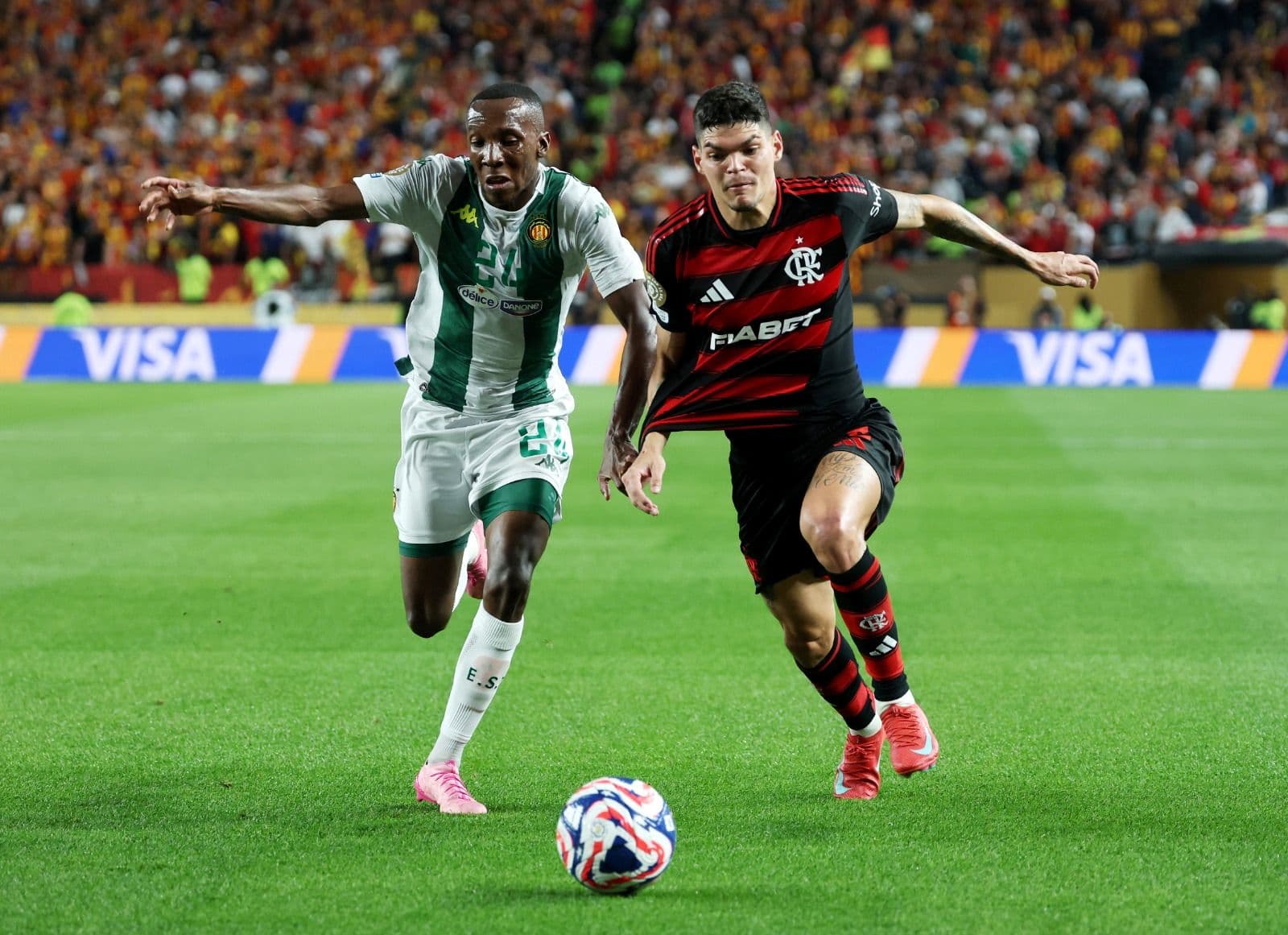 Elias Mokwana, número 24 do Esperance de Tunisie, disputa a posse de bola com Ayrton Lucas, número 6 do CR Flamengo, durante a partida do Grupo D da Copa do Mundo de Clubes da FIFA 2025 entre CR Flamengo e Esperance de Tunis, no Lincoln Financial Field, e