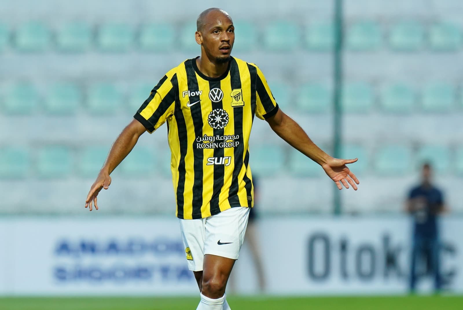 Fabinho, volante do Al-Ittihad, na mira do Palmeiras, de braços abertos em campo durante um jogo da Liga Saudita