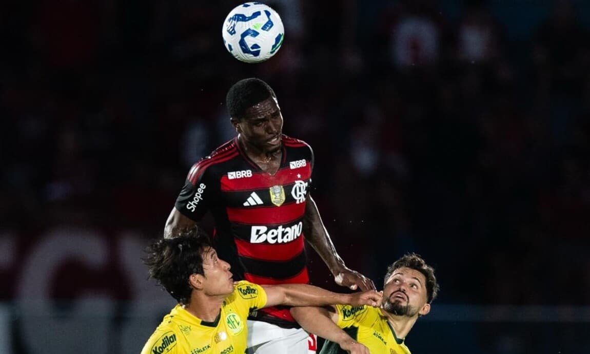 Evertton  Araújo tira a bola pelo alto enquanto dois jogadores do  Mirassol olham do chão