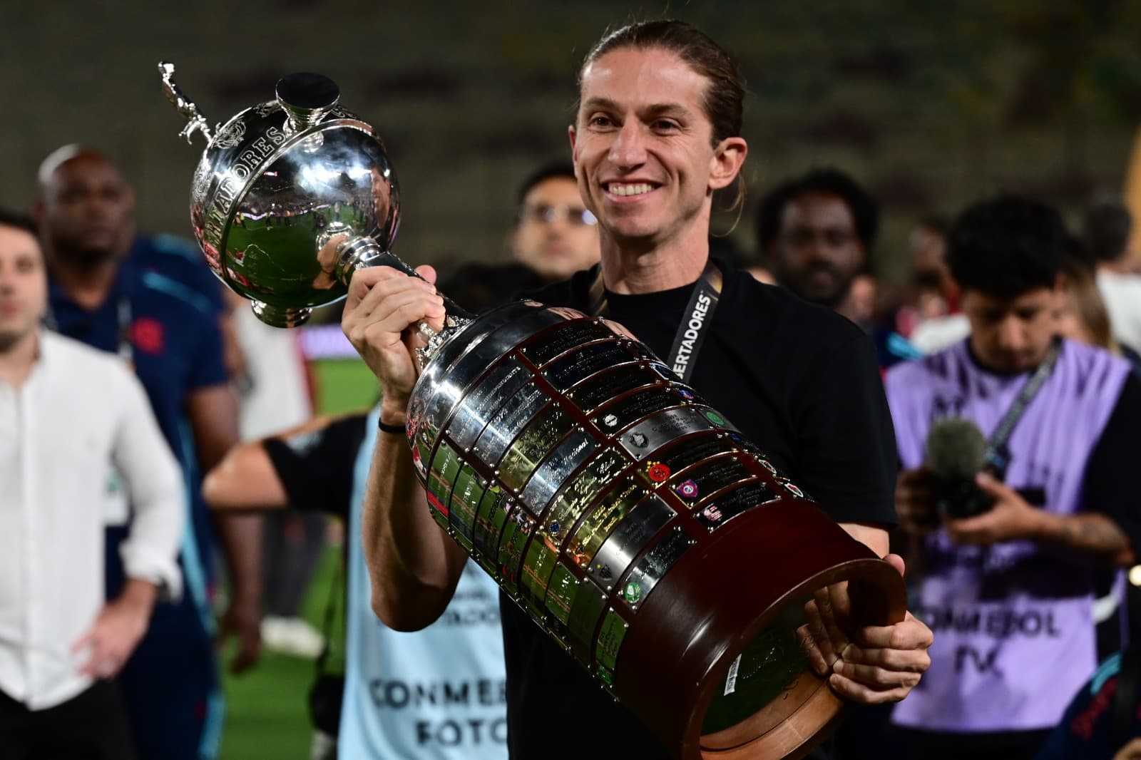 Filipe Luís sorri enquanto segura o troféu da Libertadores conquistado com o Flamengo
