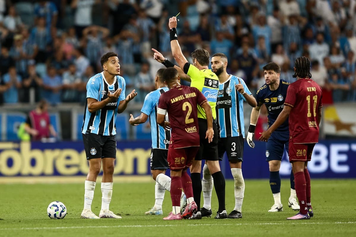 Gustavo Martins, do Grêmio, recebe cartão amarelo durante jogo contra o Fluminense, pelo Brasileirão, e gesticula contra o árbitro