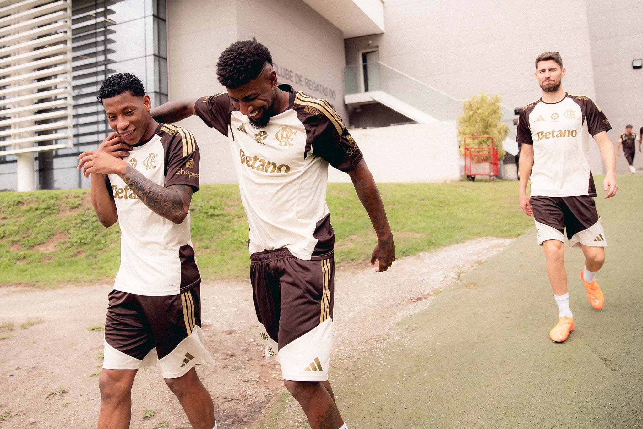 Emerson Royal e Gonzalo Plata riem abraçados ao chegar para treinar no Ninho do Urubu; Jorginho aparece atrás no treino do Flamengo