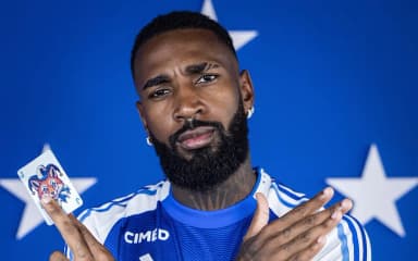 Gerson faz pose do 'vapo' e segura carta de coringa no anúncio oficial do Cruzeiro