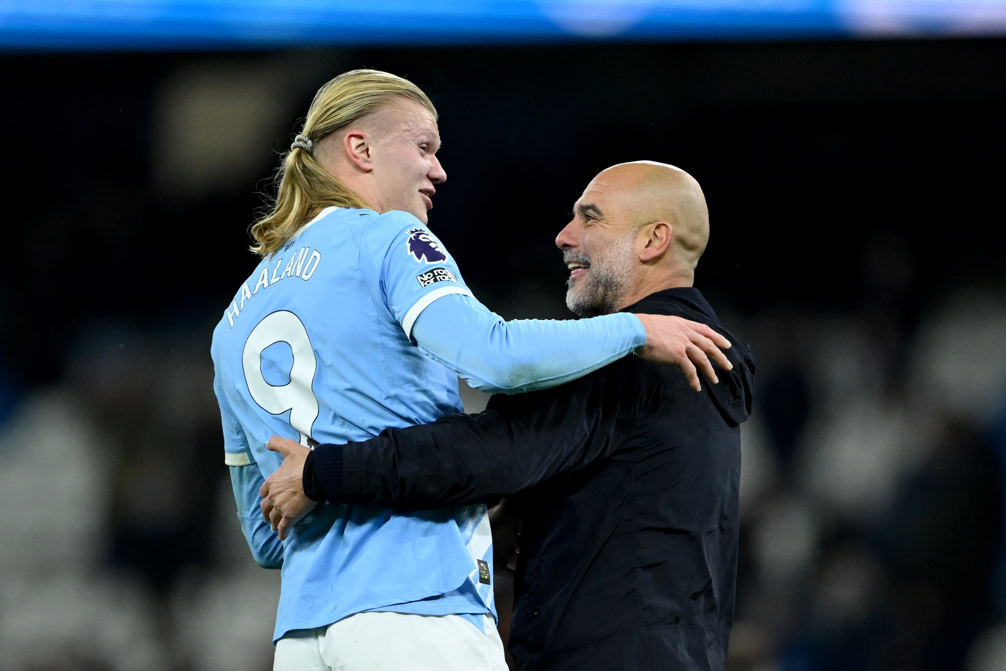 Haaland e Guardiola se abraçam sorridentes após jogo do Manchester City