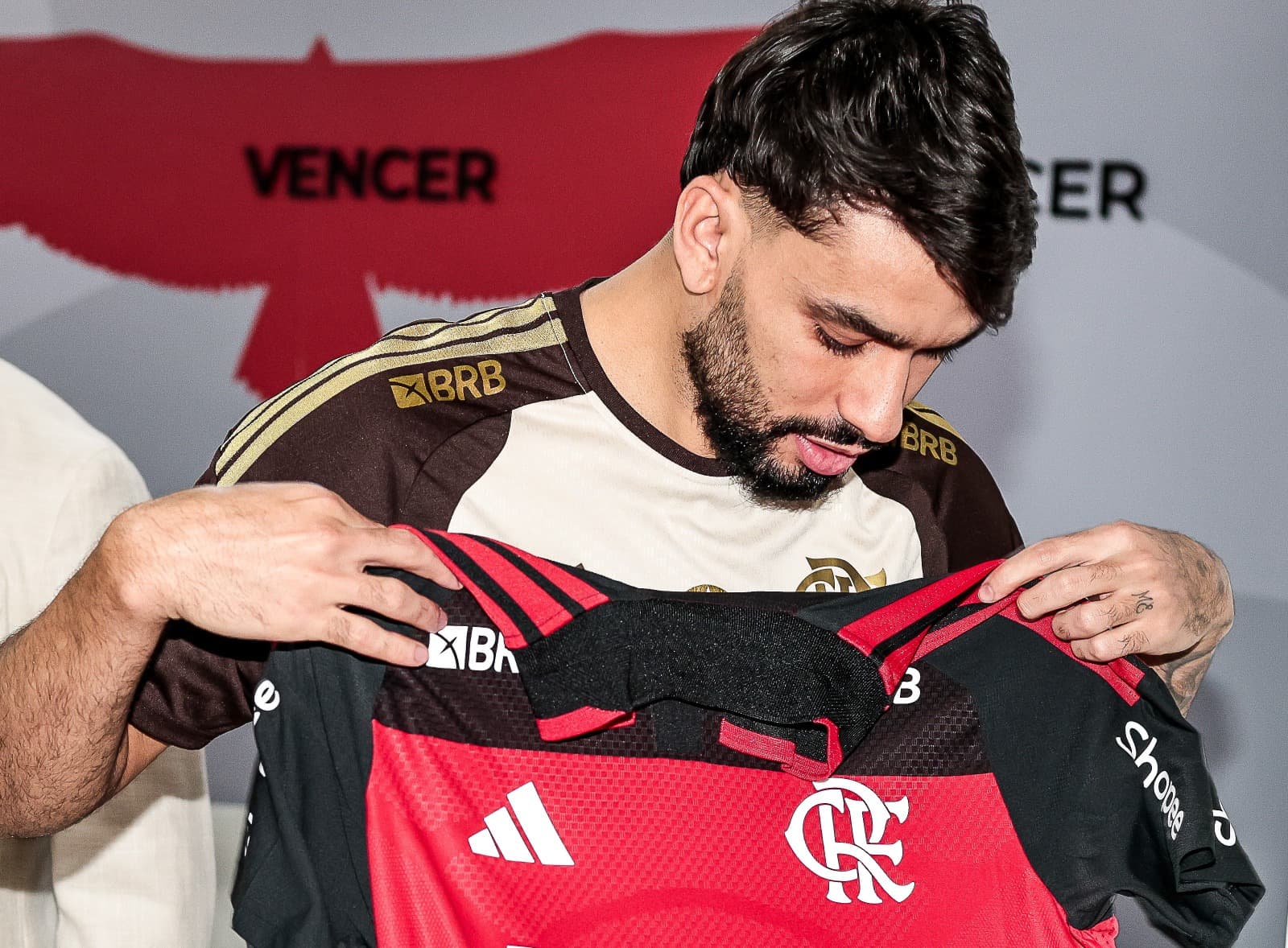 Paquetá olha para a camisa do Flamengo após assinar o contrato