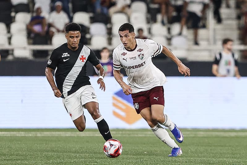 Serna carrega a bola enquanto é marcado por jogador do Vasco