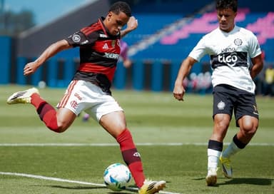 Ryan Roberto prepara finalização de pé direito enquanto é marcado por jogador do Olimpia