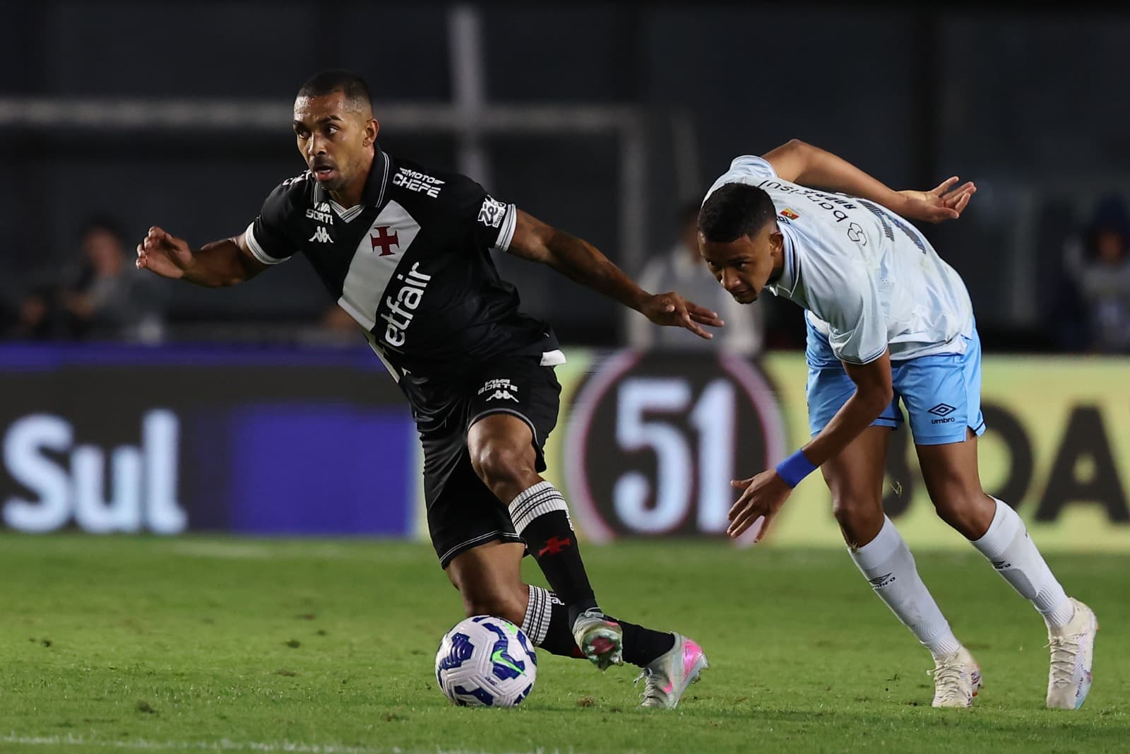 Paulo Henrique conduz a bola enquanto é marcado por jogador do Grêmio