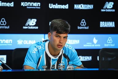 Leonel Pérez fala ao microfone com semblante sério durante coletiva de apresentação no Grêmio