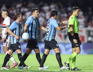 Jogadores do Grêmio andam atrás do árbitro para reclamar de lance na partida contra o São Paulo