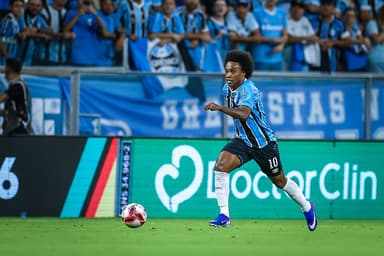 Willian, com a camisa 10 do Grêmio, corre com a bola durante o GreNal 450