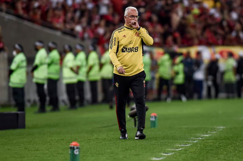 Dorival Júnior, treinador do Flamengo, caminha pensativo na área técnica