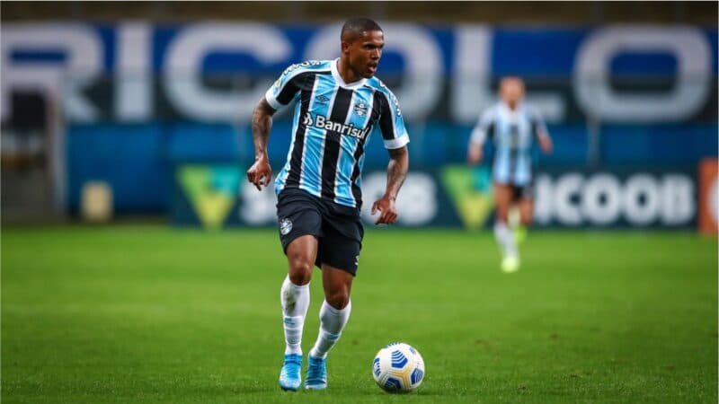 Douglas Costa jogando com a camisa do Grêmio; jogador se reuniu com Marcos Braz e pode pintar no Flamengo