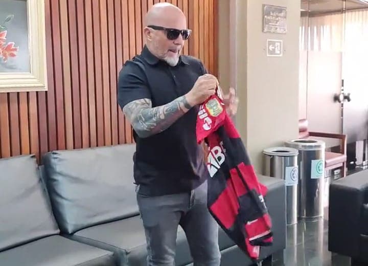 Jorge Sampaoli chega no Aeroporto Internacional do Galeão e posa com camisa do Flamengo