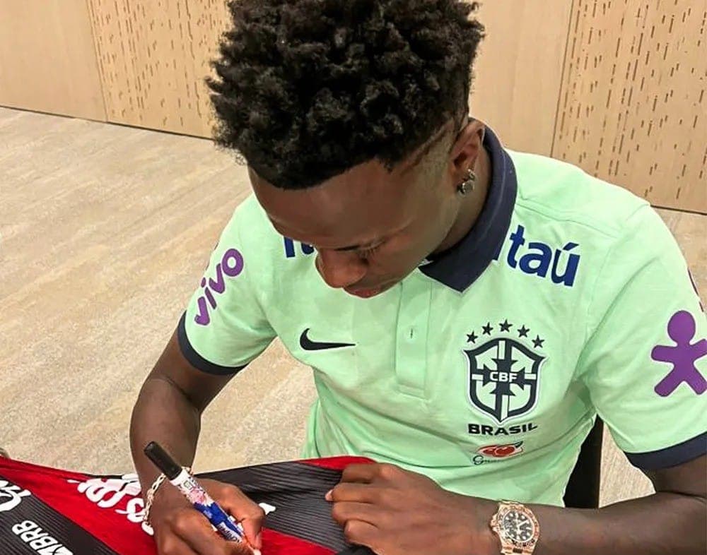 Vinícius Júnior assina camisa do Flamengo para leilão
