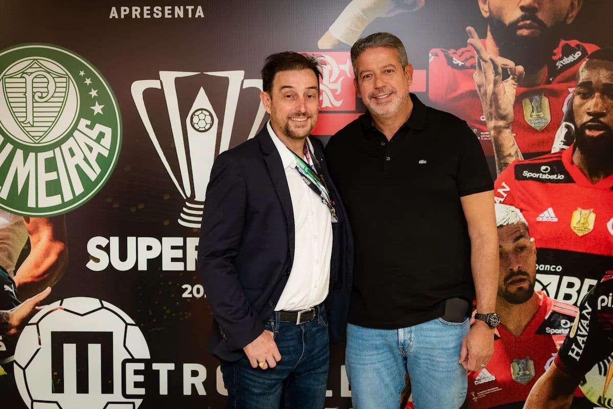 Arthur Lira (à direita) com o presidente da Arena Mané Garrincha em frente a backdrop com imagens de Flamengo x Palmeiras na final da Supercopa do Brasil, em janeiro de 2023. arthur lira sócio honorário flamengo