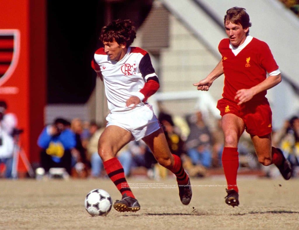 Zico domina a bola com marcador do Liverpool atrás. Flamengo venceu o Mundial de 1981 com uma grande atuação.