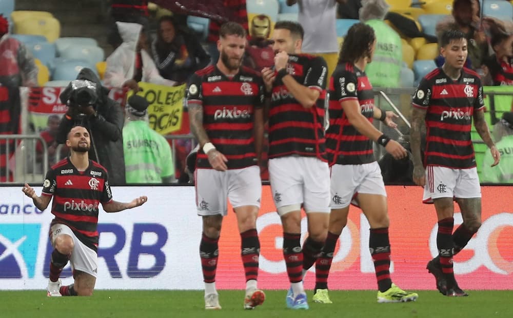 Michael ajoelhando agradecendo olhando ao céu e outros jogadores conversando durante Flamengo x Bragantino