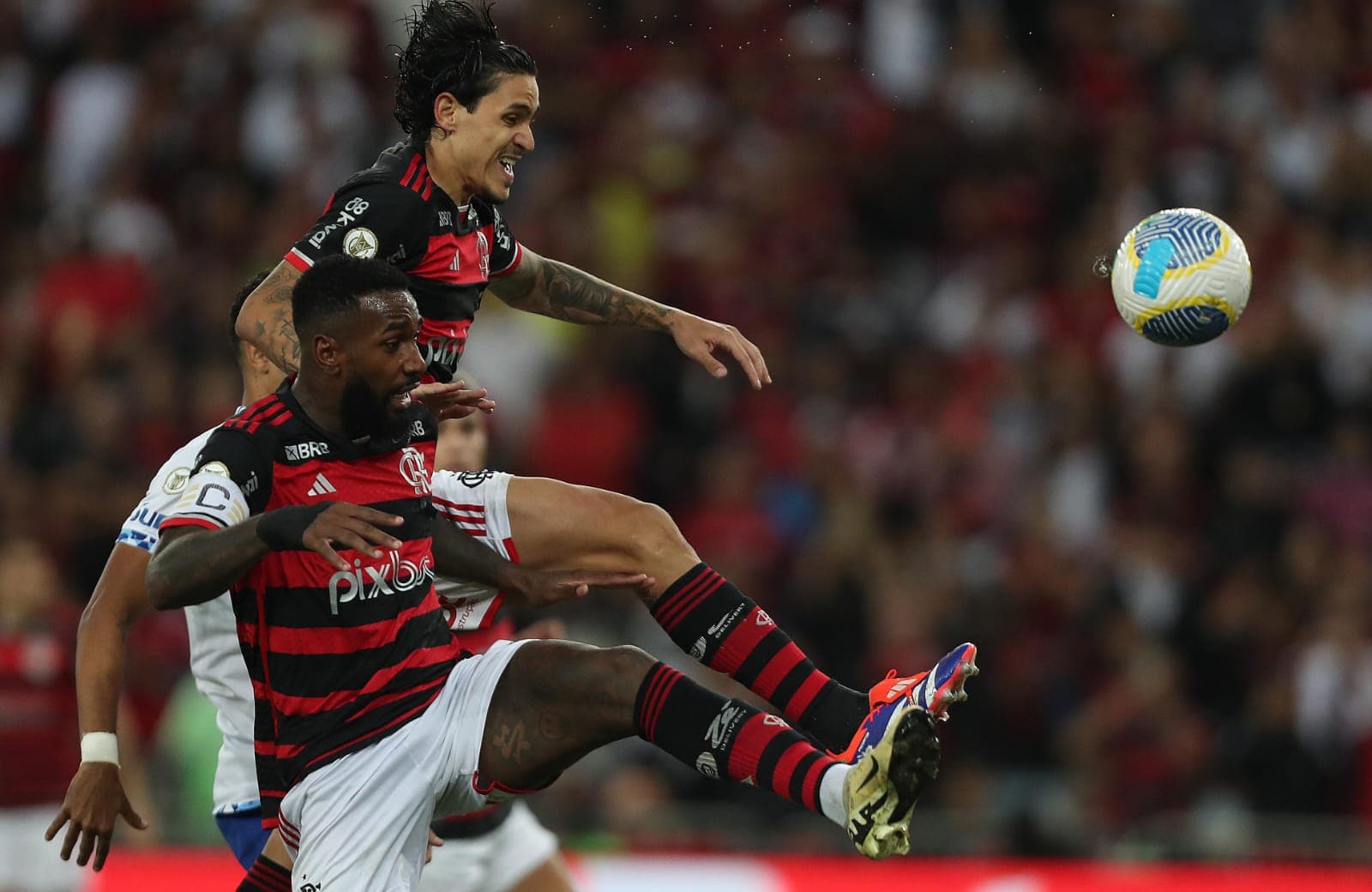 Pedro e Gerson atacam bola em jogo do Flamengo