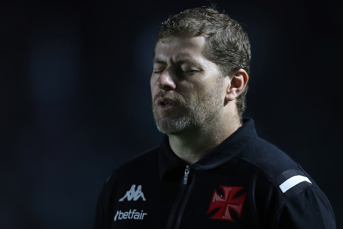 Rafael Paiva, treinador do Vasco, de olhos fechados em momento de oração durante jogo contra o Botafogo pelo Brasileirão