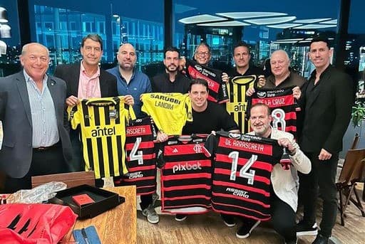 Diretorias de Flamengo e Peñarol posando com fotos das duas equipes