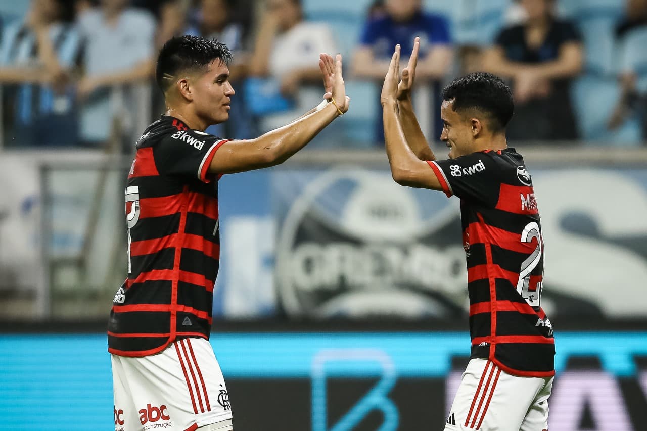Matheus Gonçalves (D) do Flamengo comemora com o companheiro de equipe Carlos Alcaraz após marcar o primeiro gol da equipe durante a partida entre Grêmio e Flamengo como parte do Brasileirão 2024 na Arena do Grêmio em 22 de setembro de 2024 em Porto Alegr