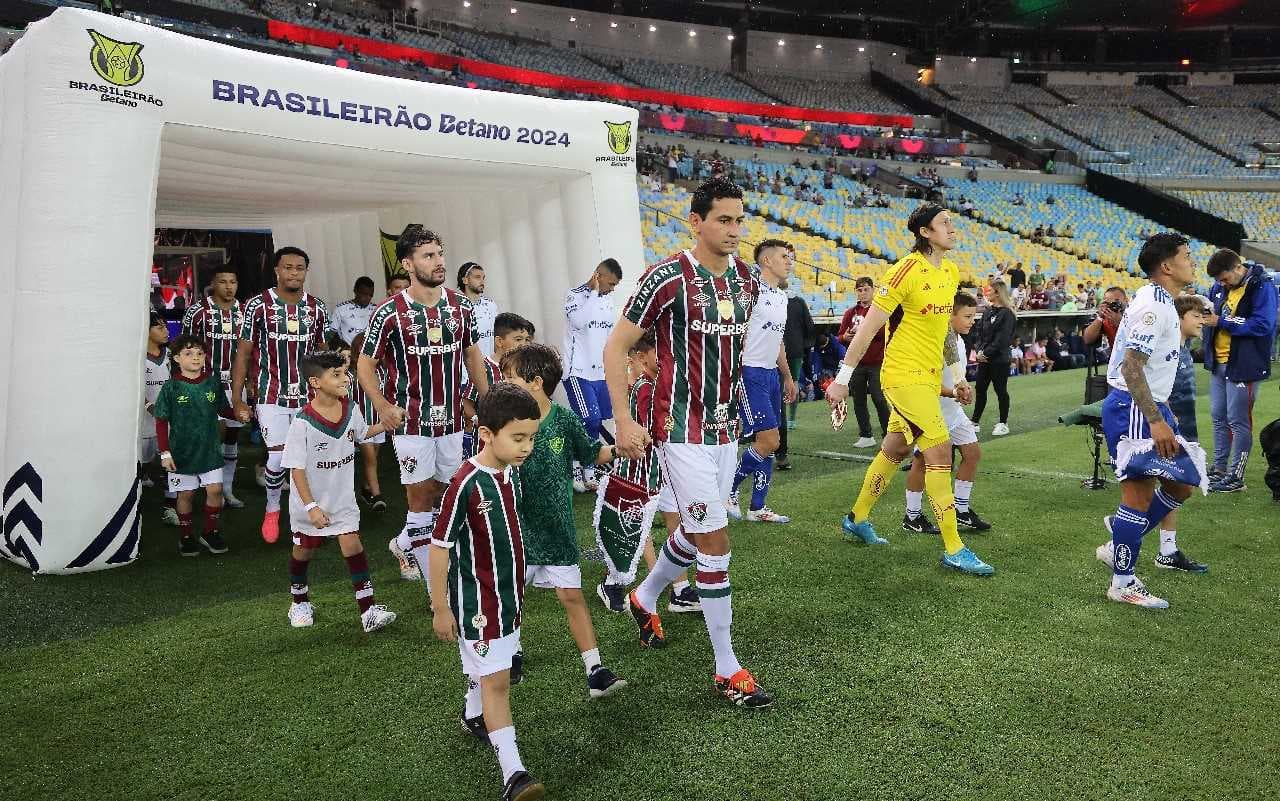 RIO DE JANEIRO, BRASIL - 3 DE OUTUBRO: Paulo Henrique Ganso (C) do Fluminense e o goleiro Cássio (2º D) do Cruzeiro entram em campo antes da partida entre Fluminense e Cruzeiro como parte do Brasileirão 2024 no Estádio do Maracanã em 3 de outubro de 2024