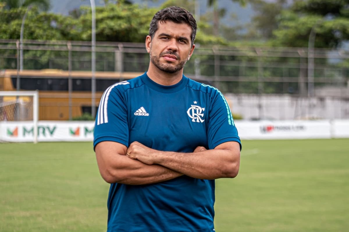 André Rocha, gerente de futebol feminino do Flamengo, com semblante sério e braços cruzados