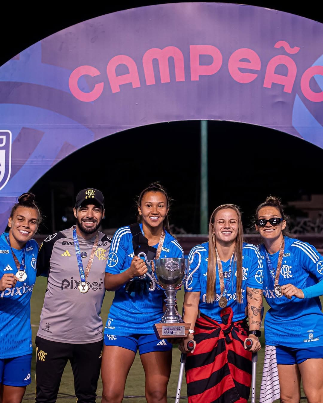na foto estão: Isa, Felipe França, Bibi que segura a taça de campeã, Gabi Barbieri que está de muletas e Karol Alves