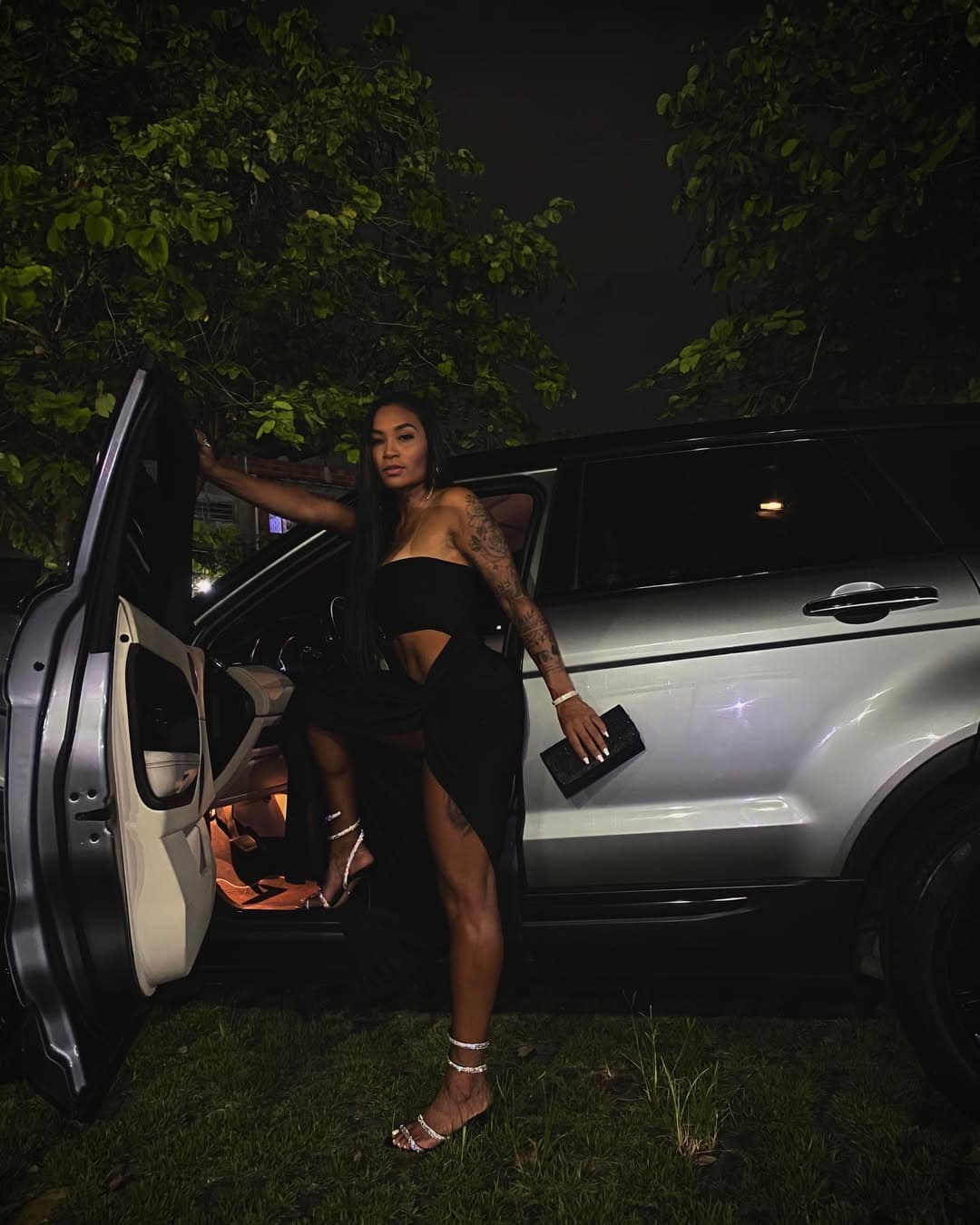 na foto a ex atleta do Flamengo, está de vestido preto, saindo de um carro com a expressão séria