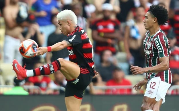 Luiz Araújo, do Flamengo, tenta dominar a bola seguido da marcação do lateral do Fluminense