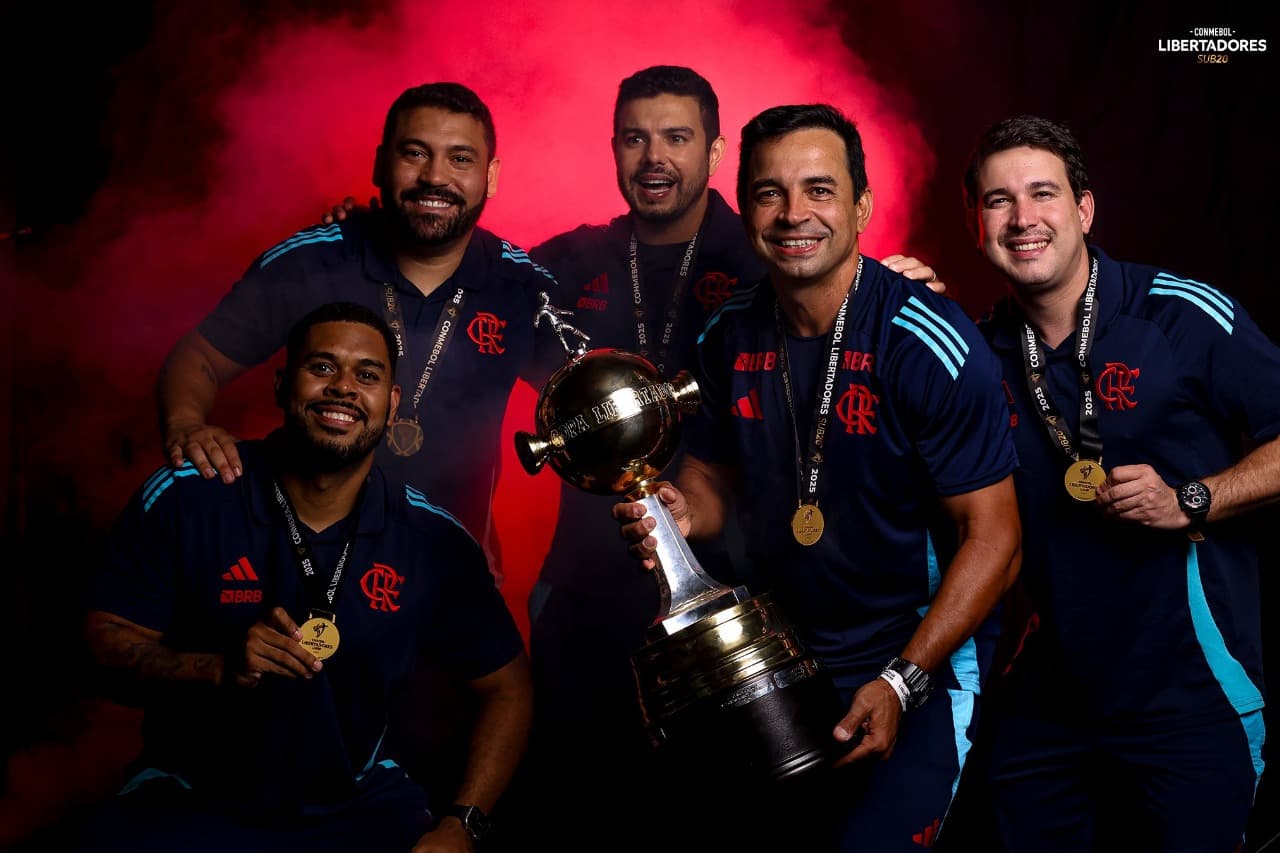 Cléber dos Santos e comissão técnica do Flamengo Sub-20 segurando a taça da Libertadores