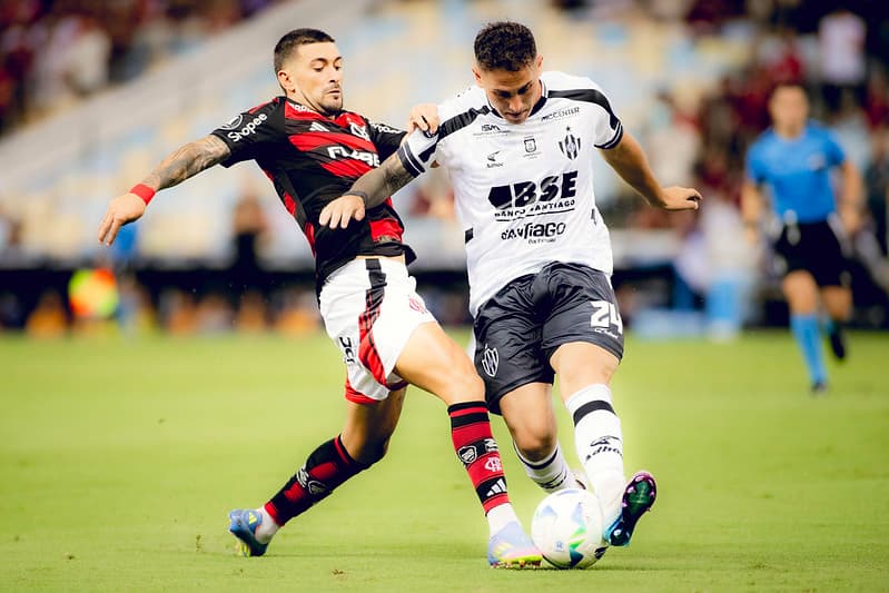 Arrascaeta disputa bola com zagueiro argentino na derrota do Flamengo para o Central Córdoba no Maracanã
