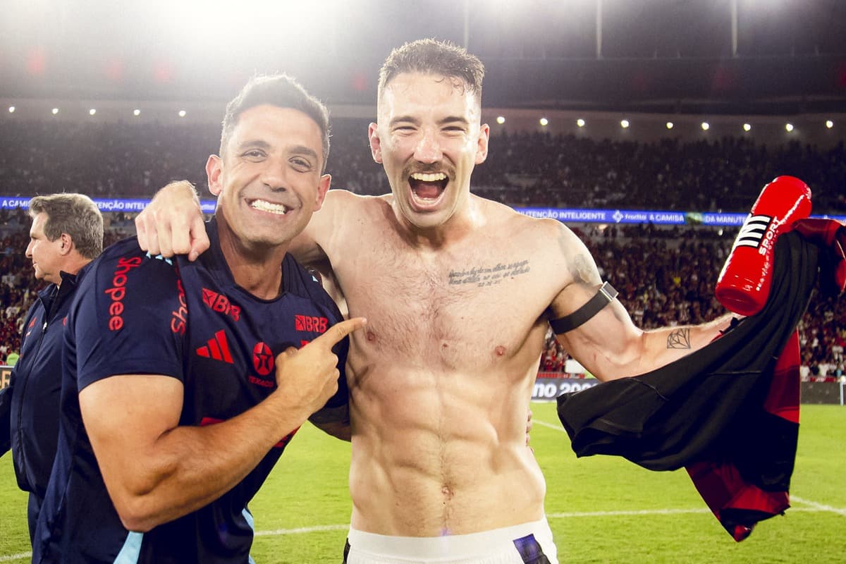 Léo Ortiz sorridente ao lado de Diogo Linhares, preparador físico do Flamengo, mostrando barriga definida após críticas sobre seu peso