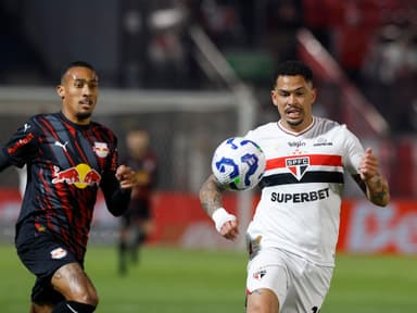 Luciano, do São Paulo, e Guilherme Lopes, do Bragantino, correm ao encontro da bola durante embate pelo Brasileirão 2025