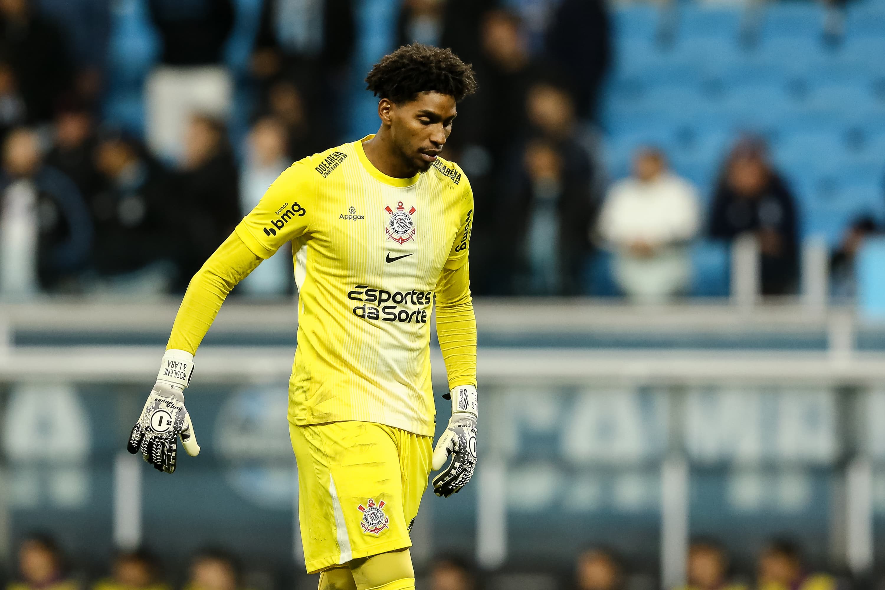 Hugo Souza olhando para o chão com olhar perdido durante jogo entre Grêmio e Corinthians, na Arena do Grêmio, pelo Brasileirão 2025