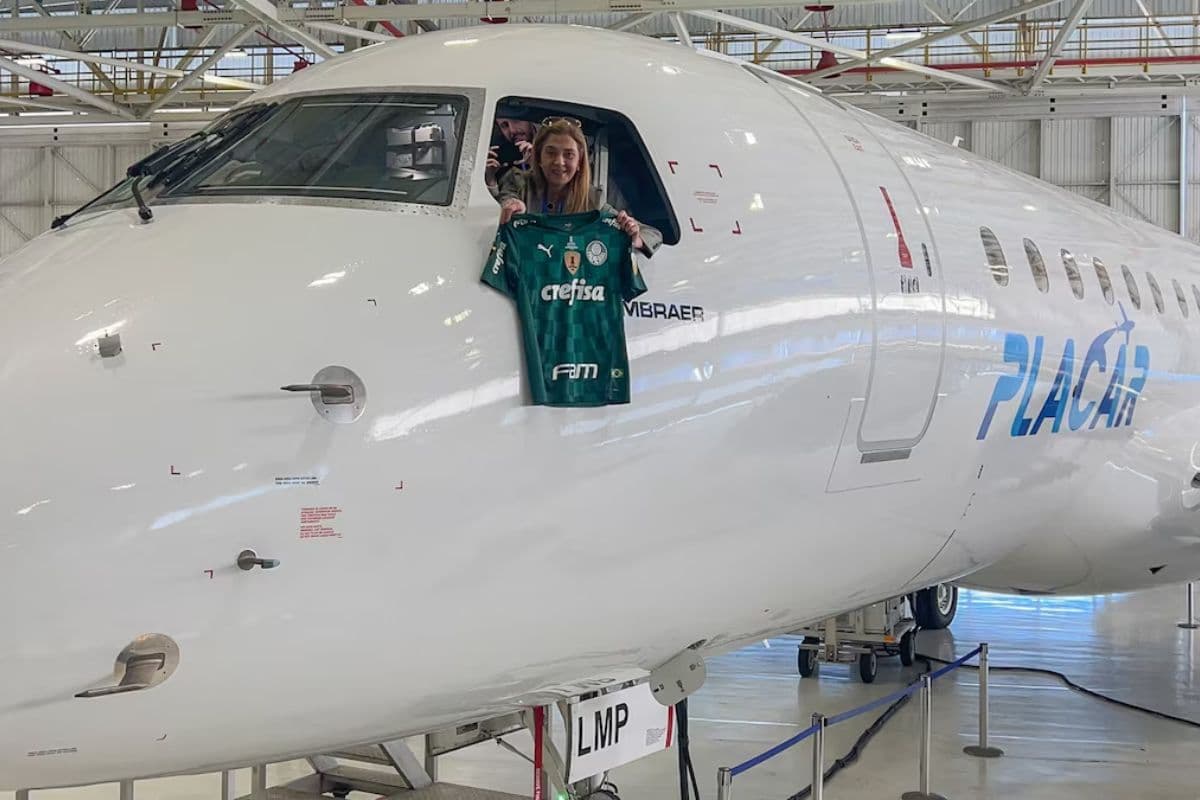 Leila Pereira, presidente do Palmeiras, posa para foto em seu avião segurando uma camisa do time