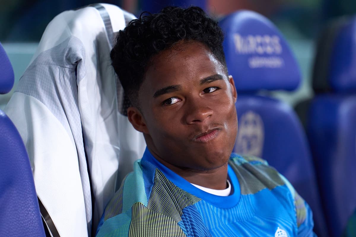 Endrick sorri no banco de reservas do Real Madrid, vestindo camisa de treino durante jogo contra o Levante