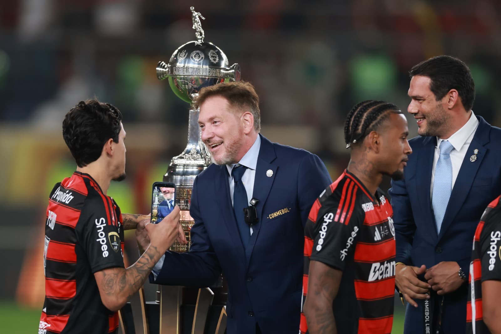O presidente da CONMEBOL Alejandro Dominguez parabeniza Pedro do Flamengo ao receber a medalha de vencedor após a final da Copa CONMEBOL Libertadores de 2025 entre Palmeiras e Flamengo no Estádio Monumental em 29 de novembro de 2025 em Lima, Peru.